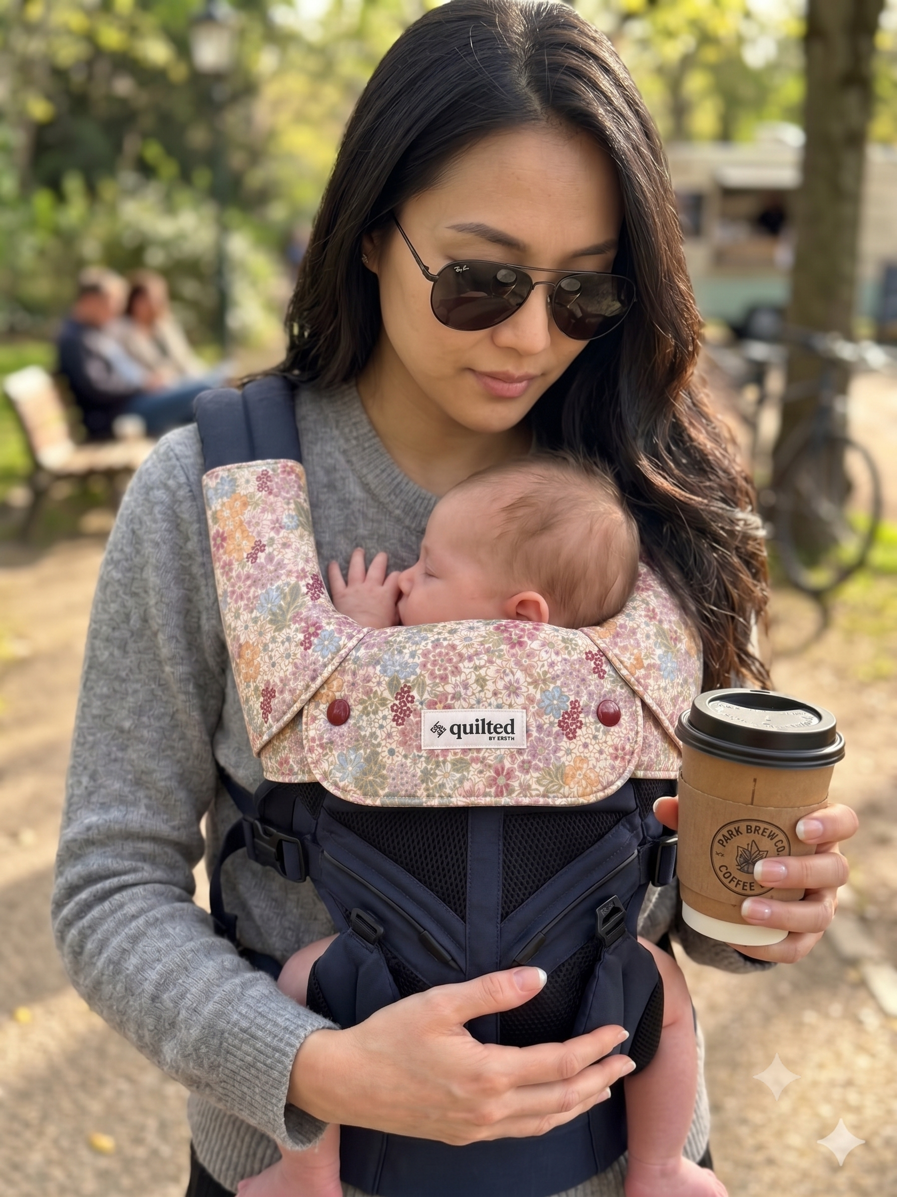 woman with baby carrier. she has on floral suckpads and droolbib